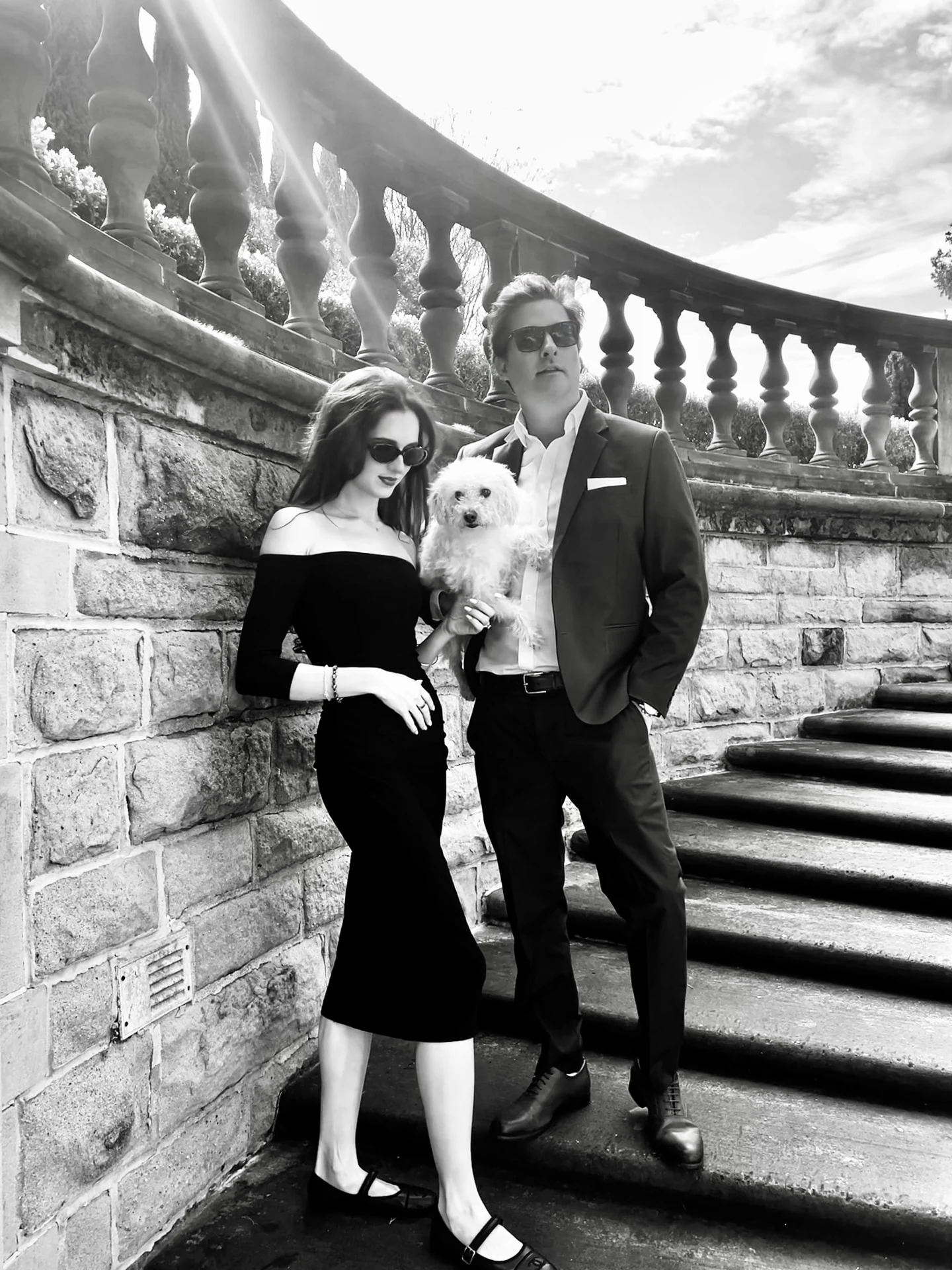 Christian and Paige with their dog on a curved stone staircase