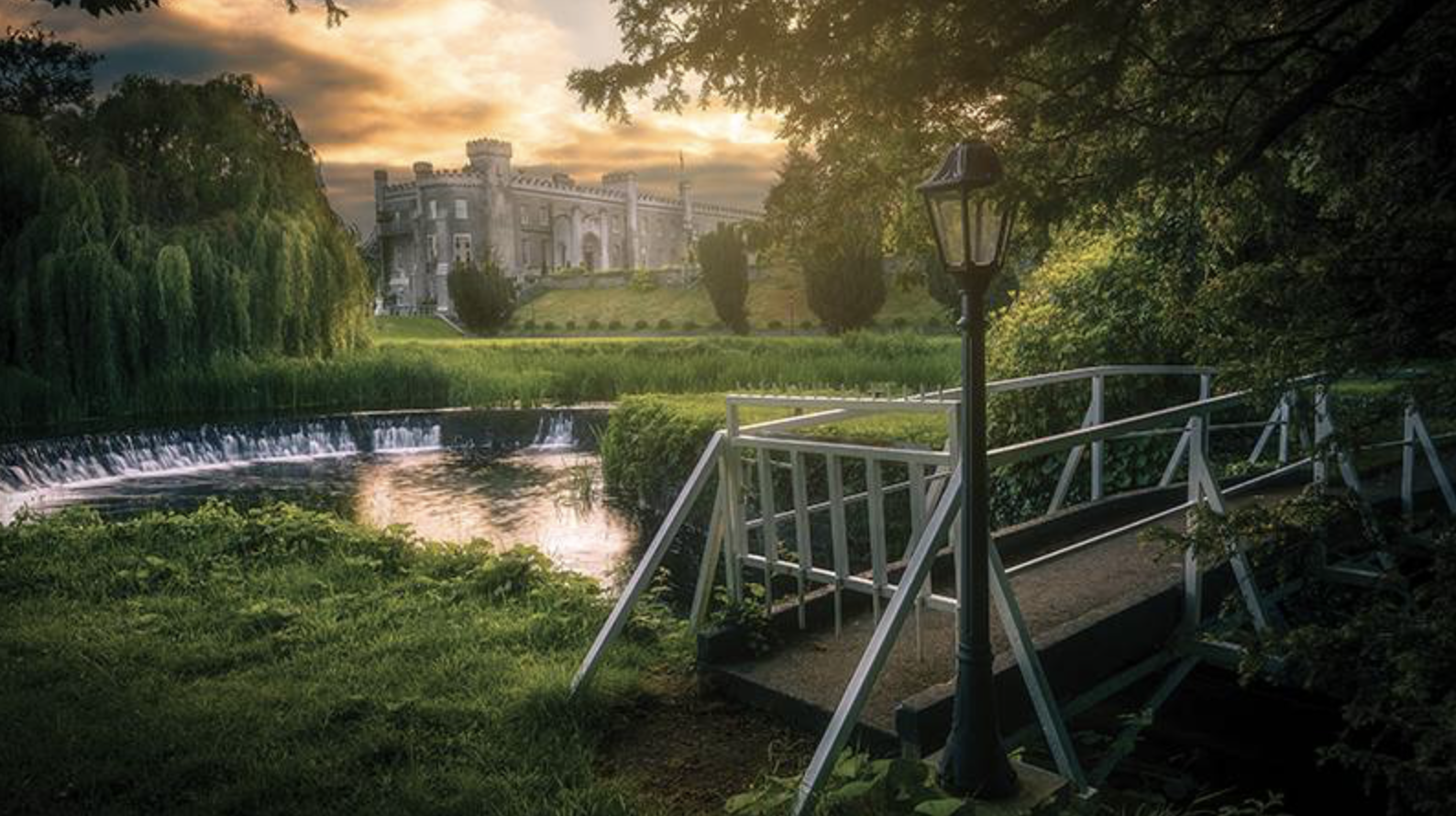 Bellingham Castle rising above the river, its warm stone reflected in the water